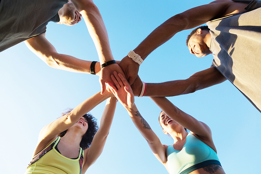 Photo of a group of people in a circle with "hands in" 